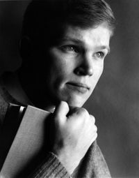 Portrait of teenage boy holding a book, inspiring curiosity and learning.