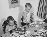 Poster print of two boys painting at a table, capturing childhood creativity and imagination.