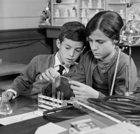 Boy and girl conducting a chemistry experiment in a laboratory poster print.