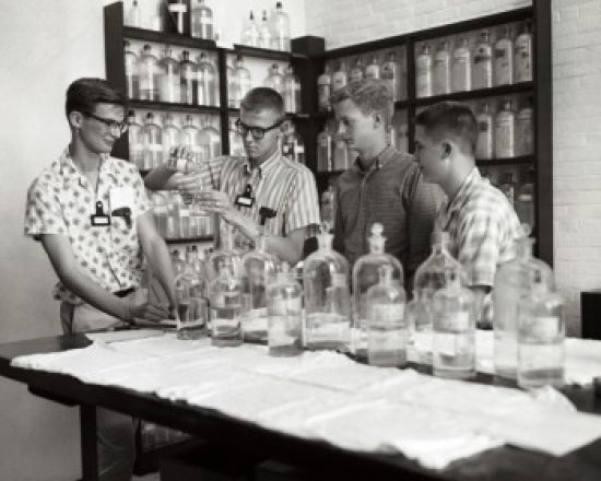 Poster of four boys conducting a chemistry experiment in a laboratory.
