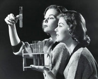 Poster print of two young women examining a solution in a test tube