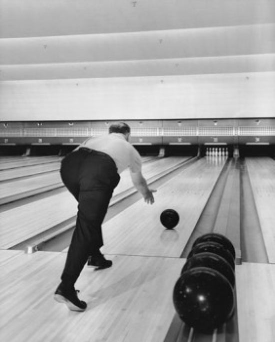 Bowling ball action poster print featuring a man rolling a bowling ball down the lane.