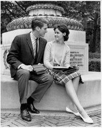Young Couple Sitting on a Pedestal Poster Print showcasing love and connection.