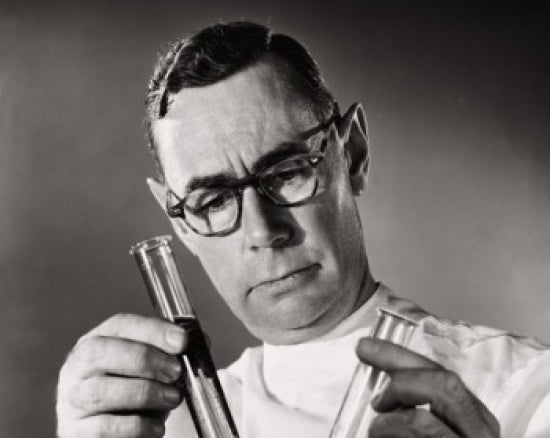 Close-up of a scientist comparing chemicals in test tubes poster print