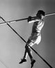 Dynamic low angle view of a young man pole vaulting poster print.