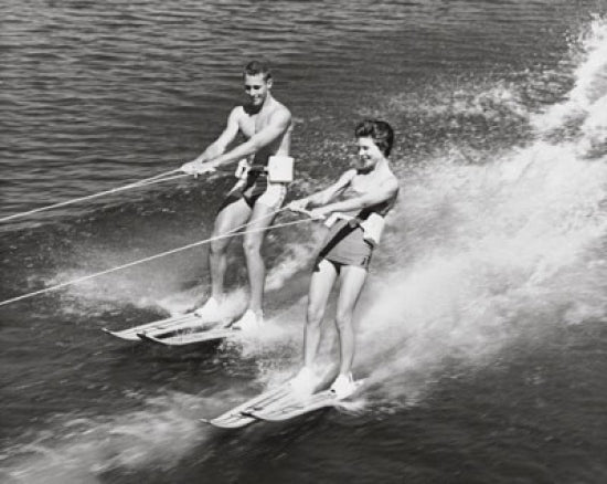 Young couple waterskiing poster print capturing summer fun and adventure.