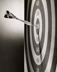 Close-up of a dart on a dartboard poster print