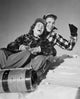 Young couple sliding on a sled in winter scenery poster print