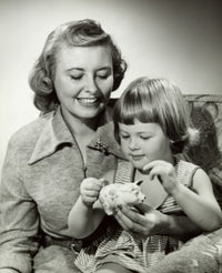 Close-up of a mother watching her daughter putting a coin into a piggy bank poster print