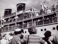 Group of people standing near a departing cruise ship poster print.