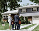 Rear view of parents with children in front of a house poster print.