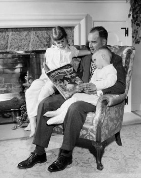 Father reading Alice in Wonderland to children poster print.