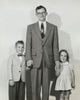 Portrait of a mid adult man standing with his son and daughter poster print.