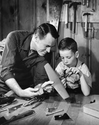 Close-up poster print of a father and son making an airplane model.