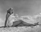 Low angle view of a young woman sunbathing on the beach poster print.