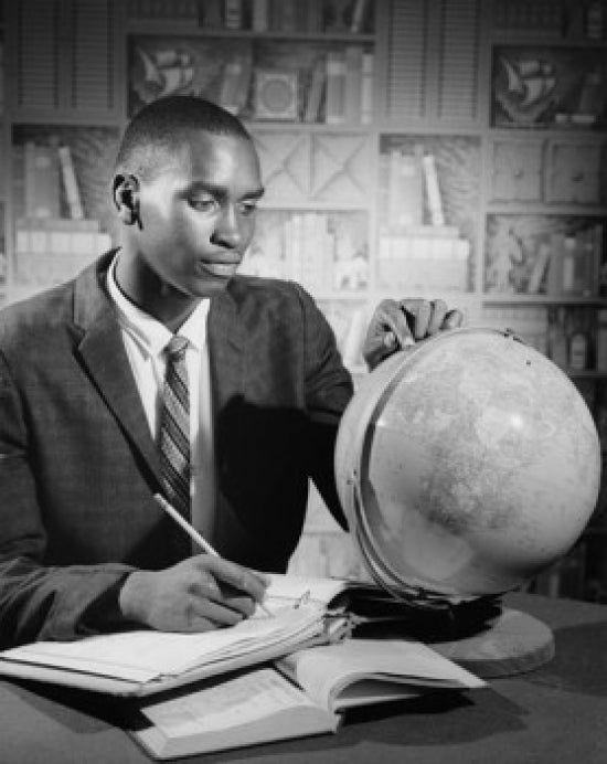 Teenage boy studying a globe poster print, educational decor.