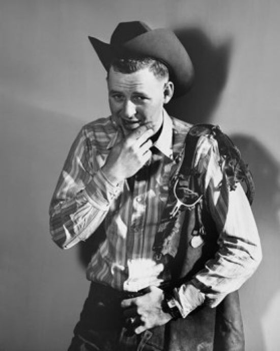 Portrait of a cowboy with saddle on his shoulder poster print