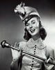 Close-up poster print of a drum majorette smiling and holding a baton.