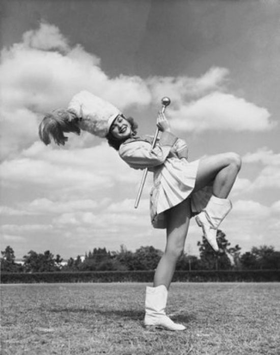 Drum Majorette performing with a twirling baton in a field poster print.
