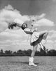 Drum Majorette performing with a twirling baton in a field poster print.