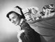 Close-up of a young woman carrying a sack of Christmas presents on her back.