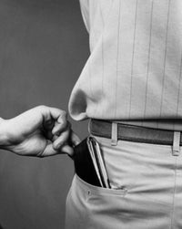 Close-up of a hand taking a wallet from a man's back pocket