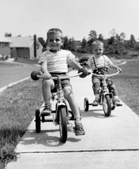 Poster of two boys riding tricycles along a path