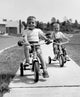 Poster of two boys riding tricycles along a path