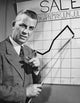 Businessman pointing at a line graph poster print