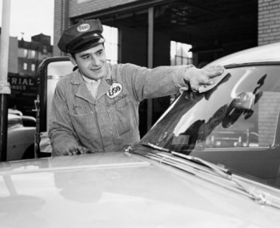 Gas station attendant cleaning the windshield of a car poster print.