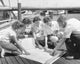 Parents and children looking at a map on a pier poster print
