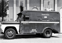 Armored Truck in Front of a Building Poster Print showcasing urban life