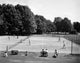 Group of people practicing tennis on a tennis court poster print.