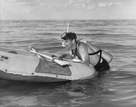 Young man relaxing on an inflatable raft poster print.