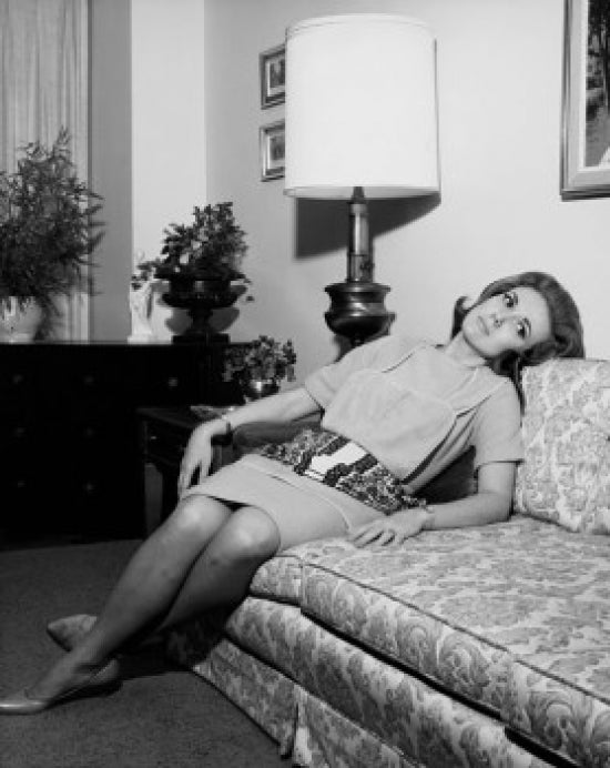 Young woman reclining on a couch poster print