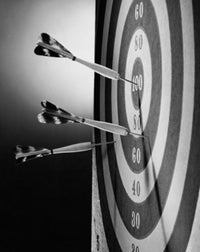 Close-up poster of darts on a dartboard