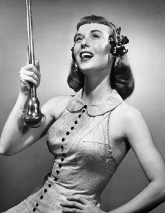 Close-up of a drum majorette performing with a twirling baton and smiling.