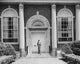 Man standing in front of the door of a bank poster print