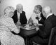 Poster print of two senior couples playing Chinese checkers, capturing a joyful moment.