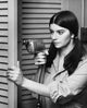Close-up of a young woman drilling into a door poster print