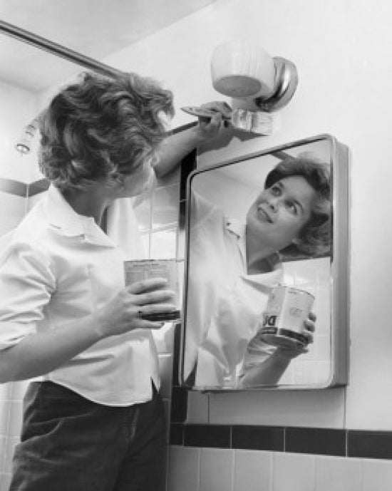 Young woman painting a wall in the bathroom poster print.