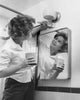 Young woman painting a wall in the bathroom poster print.