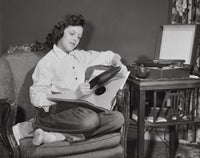 Poster print of a teenage girl sitting in an armchair holding a record.