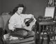 Poster print of a teenage girl sitting in an armchair holding a record.