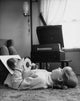 1965 poster print of a girl lying on a carpet holding records.