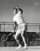 Dynamic tennis action poster print featuring a young man playing tennis from a low angle view.