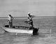Three men fishing on a motorboat in the sea poster print.