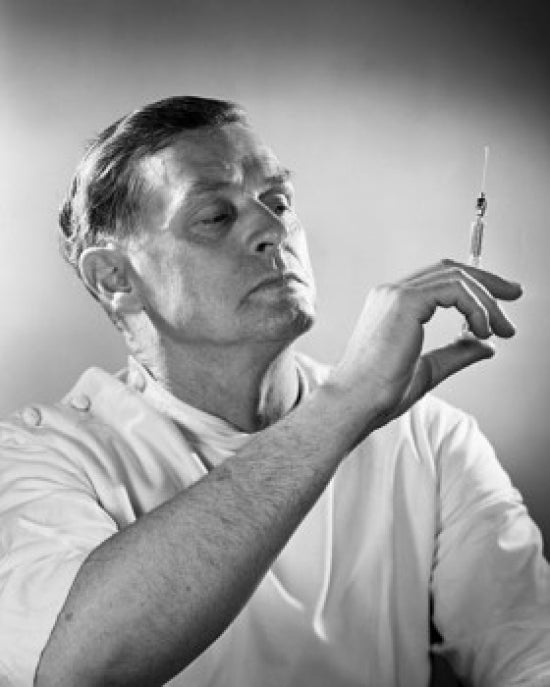 Close-up of a male doctor holding a syringe poster print.