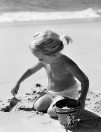 Girl Digging Sand on Beach Poster Print