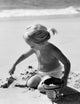 Girl Digging Sand on Beach Poster Print
